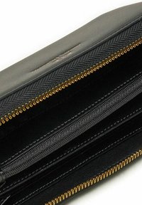 Portafoglio nero con un'esterno in tessuto testurizzato, corretta con zip in oro e molteplici scomparti per l'organizzazione.