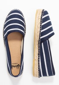 Mörkblå espadrilles utan snörning med vita ränder, i bomullstyg, rundad tå, sula omsluten av jute och gummiyttersula för grepp.