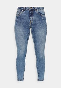 Jeans justos feitos de denim azul. Apresenta cinco bolsos, fecho de correr frontal e costura em contraste. Perna afunilada com uma bainha limpa.