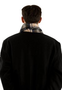 Manteau en laine noir avec une finition texturée, doté d'une écharpe en tartan multicolore dans des teintes de crème, bleu marine et jaune enroulée autour du cou.