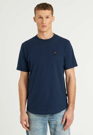 Marinblå t-shirt med kort ärm i bomull, med en liten svart logotyp på bröstet och rund halsringning.