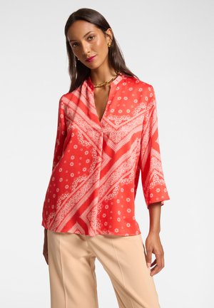Blusa rossa a fantasia realizzata in tessuto leggero, con colletto alla mandarina, maniche a tre quarti e un design paisley con accenti floreali.