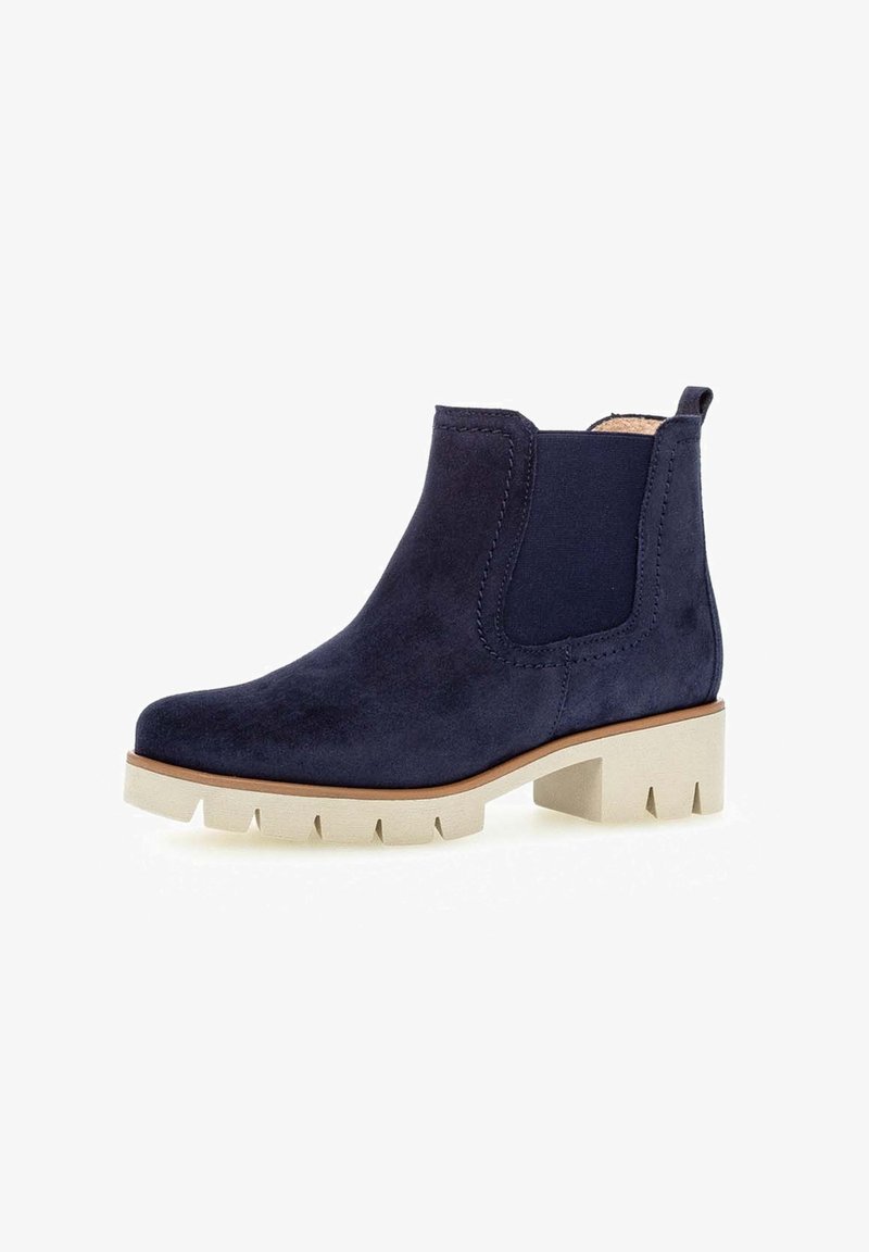 Bottine en daim bleu marine avec semelle épaisse beige, panneaux latéraux élastiques, languette à l'arrière et petit talon bloc pour un usage décontracté.