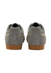 Sneaker grigie in suede con suola in gomma, dotate di profilo basso, punta tonda e dettaglio di cucitura a contrasto sui lati.
