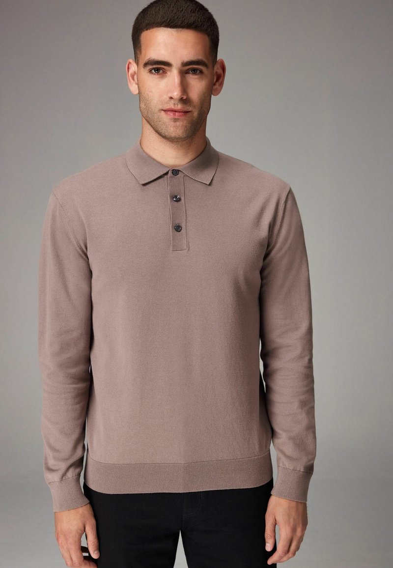 Brun langærmet polo skjorte med krave, tre-knaps lukning, ribbede manchetter og nederdel. Glat tekstur og tætsiddende design.