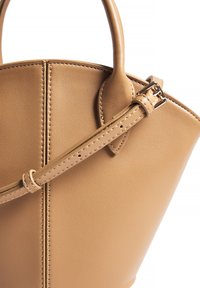 Tan leather handbag with a structured design, featuring a top handle and an adjustable strap secured by a metal buckle. Smooth texture with stitching details.