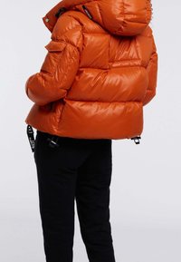 Pomarańczowa puchowa kurtka z kapturem, z pikowanym wzorem, teksturowanym wykończeniem oraz czarnymi regulowanymi paskami. Widok z tyłu bez widocznych logo.