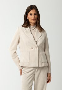 Beige corduroy blazer met een dubbele knoopsluiting, twee voorzakken en een gesneden revers. Getextureerde stof met verticale strepen.