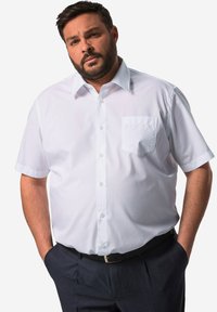 Camicia bianca a maniche corte con bottoni, dotata di tasca sul lato sinistro del petto, caratterizzata da un colletto classico, tessuto morbido e vestibilità rilassata.