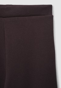 Leggings viola scuro realizzati in tessuto morbido e elastico, con una texture liscia e una cintura elastica per il massimo comfort.