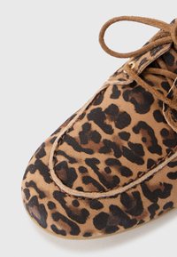 Leopardi mustriga suede kingad, ümmarguse toes, kontrastsete tumedate laikudega, pruuni paelaga ning nähtava õmblusetööga ülemisel osal.