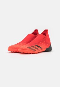 Scarpe da ginnastica rosse con design slip-on, tomaia testurizzata, accenti neri e suola robusta per una buona aderenza. Costruzione leggera e flessibile.