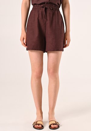 Braune Leinen-Shorts mit einer lockeren Passform, ausgestattet mit einem Kordelzugbund und seitlichen Taschen. Kombiniert mit gewebten Slidesandalen.