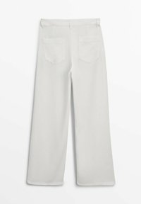 Pantalon blanc à jambes larges vu de dos, avec deux poches, passants pour ceinture et un ourlet droit sur un fond uni.