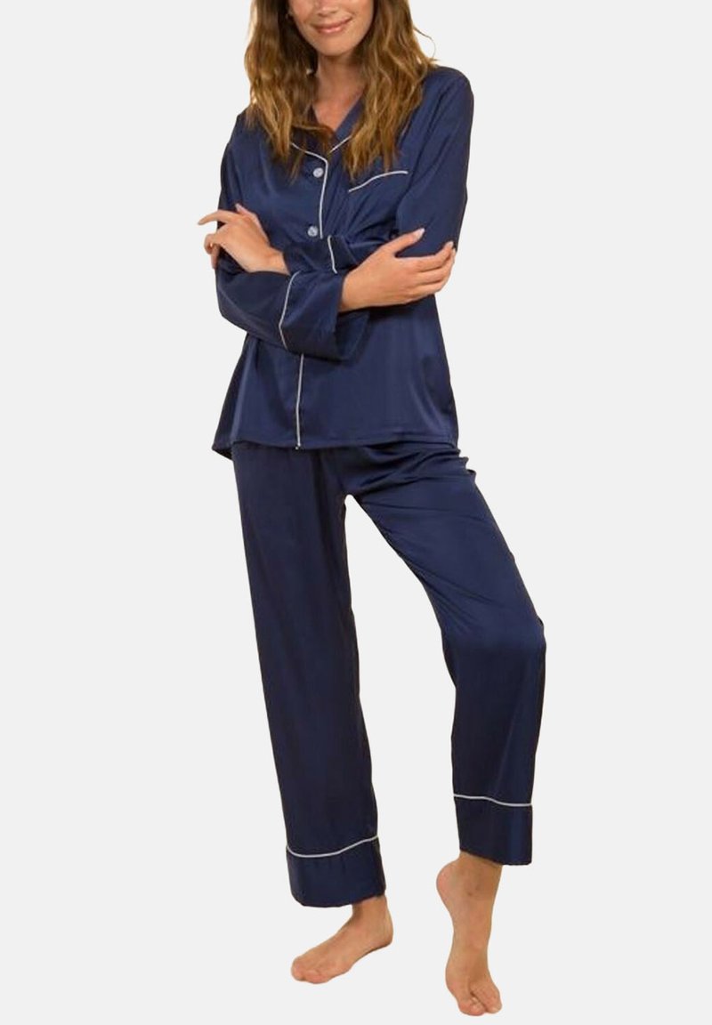 Ensemble de pyjama bleu marine en tissu lisse avec des manches longues et un pantalon assorti ; comporte un passepoil blanc le long du col, de la poche et des poignets du pantalon.