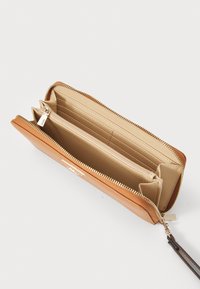 Tan leather wallet with gold-tone zipper, two main compartments, multiple card slots, and an interior zip pocket for coins.