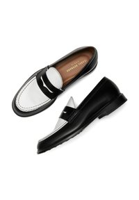 Zwarte en witte leren loafers met een spitse neus, contrasterende texturen en een decoratieve band over de wreef. Kenmerkende logo op de binnenzool.