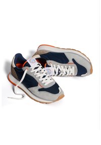 Navy and gray suede sneakers with white laces, orange accents, and a textured rubber sole. Features a round logo on the tongue.