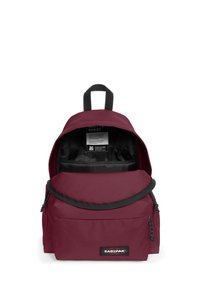 Bordový batoh z odolné látky, s přední kapsou na zip, černým interiérem a nastavitelnými popruhy, vybavený rukojetí na vrchu a logem.