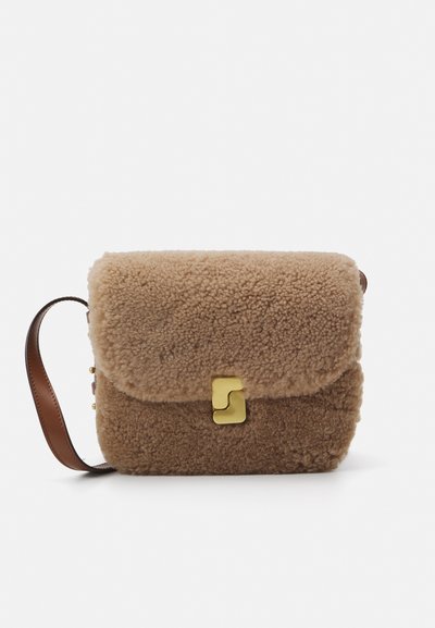 Bolso de shearling marrón con cierre de solapa, herrajes dorados y correa de cuero marrón. Textura suave, forma rectangular y tamaño compacto.