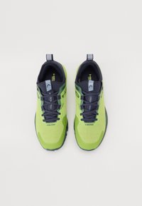 Baskets de sport vert lime avec des accents bleu marine, tige en mesh, bout rond et semelle extérieure en caoutchouc robuste ; dotées de lacets et d'une languette.