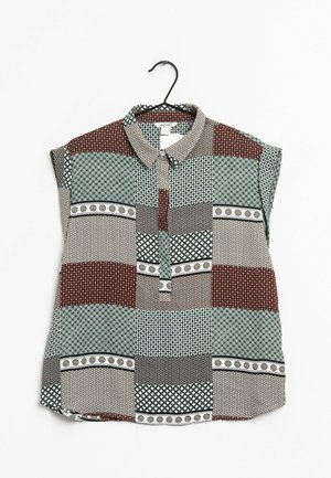 Camicia a maniche corte con colletto a bottone, caratterizzata da un design a patchwork in marrone, verde e nero con vari motivi geometrici.