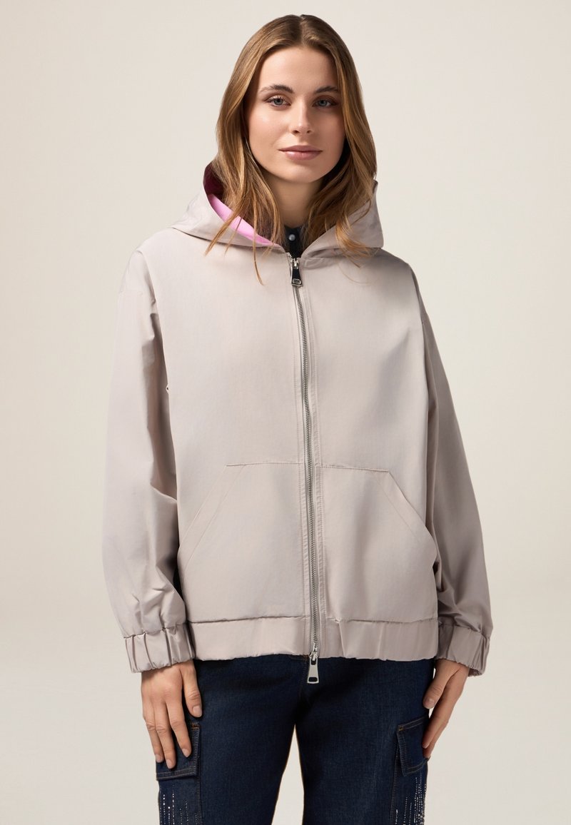 Lichtgrijze hooded jacket met een ritssluiting aan de voorkant, elastische manchetten en twee voorzakken, met een roze binnenvoering en een zachte stoftextuur.