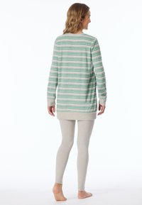 Långärmad randig topp i mintgrön och kräm, med rundad hals och förlängd bak. Matchad med ljusgrå tajta leggings.