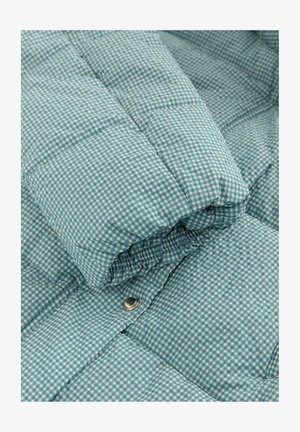 Quilted blue checkered fabric, featuring a pattern of small squares. Soft texture with a silver snap button detail.