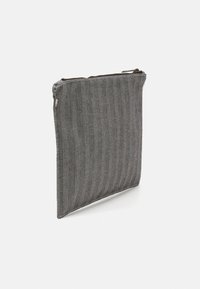 Siva torbica iz herringbone tkanine z zadrgo. Oblikovanje ima teksturirano površino in vitko pravokotno obliko.