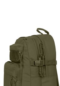 Mochila verde oliva con múltiples compartimentos con cremallera, bolsillo de malla, correas ajustables y tela duradera con una textura suave.