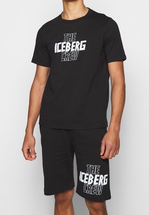 Ensemble t-shirt en coton noir et short avec un logo blanc audacieux "THE ICEBERG CREW." Encolure ronde simple et coupe décontractée avec manches courtes.