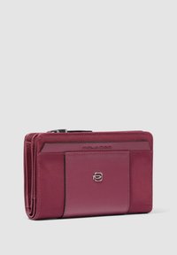 Cartera de cuero marrón con un exterior suave, múltiples ranuras para tarjetas y un logotipo en tono plateado. Cuenta con un cierre de cremallera y un diseño compacto.