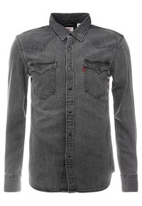 Harmaa farkkupaita, jossa pitkät hihat, edessä napit, kaksi rintataskua ja lännen tyylinen yläosan muotoilu. Pehmeä rakenne, klassinen tyyli.