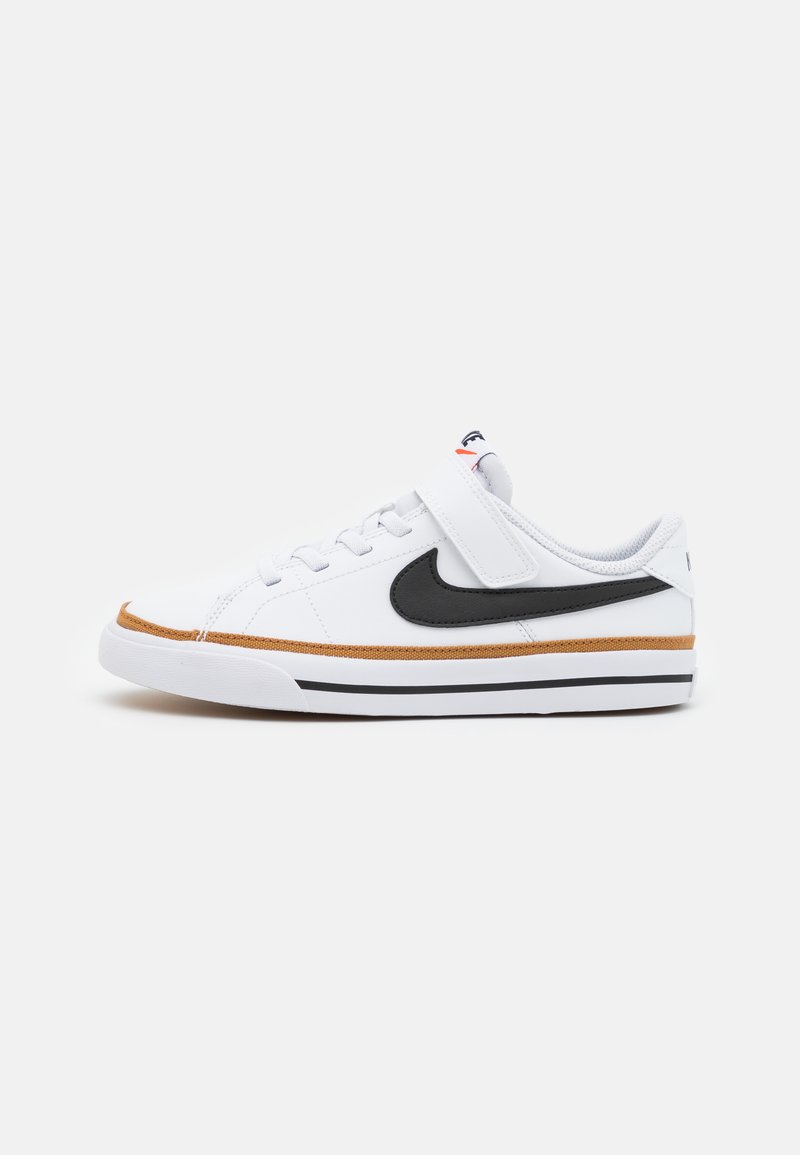 Valkoinen urheilukenkä mustalla swoosh-logolla. Varustettu tarranauhalla, kuvioidulla ruskealla välipohjalla ja mustilla raitakoristeilla. Tekstiili- ja kumimateriaaleja.