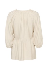 Blusa crema con scollo tondo arricciato, maniche a sbuffo e design a peplo. Realizzata in un tessuto leggero e testurizzato.
