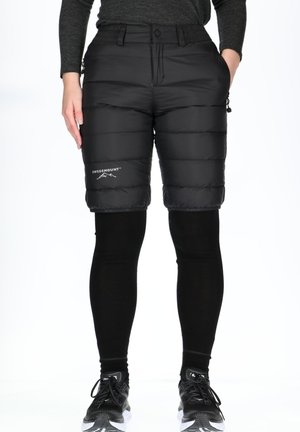 Black insulated shorts with quilted pattern, zip pockets, and an adjustable waistband, paired with black leggings and athletic shoes.