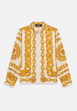 Camicia button-up color crema con audace stampa di catene dorate e dettagli con medaglioni. Presenta maniche lunghe e colletto classico. Tessuto morbido.