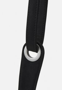 Czarny pasek skórzany o gładkiej fakturze z okrągłym srebrnym metalowym pierścieniem w punkcie łączenia. Minimalistyczny design.