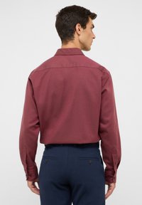 Bordeaux kleurig overhemd met lange mouwen en een soepele textuur, voorzien van een button-down kraag en verstelbare manchetten, gecombineerd met marineblauwe broek.