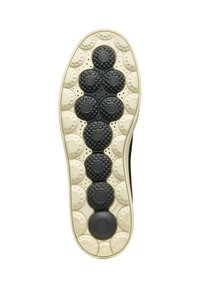 Suela de zapato de goma negra con patrones circulares; elementos de agarre texturizados de diferentes tamaños; entresuela crema en contraste.