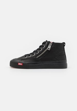 Zapatilla negra de piel con caña alta, cremallera lateral, cordones y logo de Diesel en la suela de goma cerca de la puntera.