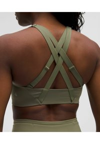 Olivgrüner Sport-BH mit Kreuzdesign im Rücken, verstellbaren Trägern und glattem Stoff. Ideal für den Einsatz im Sport.