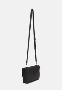 Svart läder crossbody-väska med en smal rektangulär form, slät textur, justerbar rem och dragkedjestängning; har sömmönstersaccent.