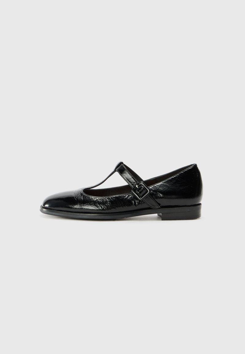 Chaussure plate Mary Jane en cuir verni noir avec un bout arrondi et une bride à boucle unique sur le cou-de-pied.