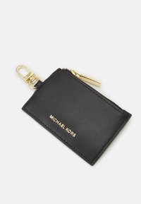 Černý kožený pouzdro na vizitky se zlatým zipem a kováním, s vyraženým logem značky na přední straně a karabinou pro připevnění.