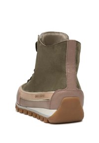 Botte en daim vert avec une touche en cuir rose, bout rond, semelle en caoutchouc texturée et col rembourré pour le confort et le soutien.