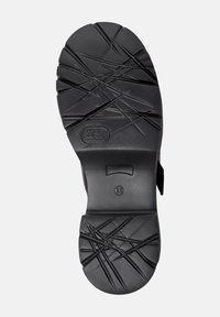 Semelle de chaussure en caoutchouc noir présentant un motif de bande de roulement texturé avec des lignes croisées ; taille indiquée comme 38. Surface lisse avec une légère courbure.