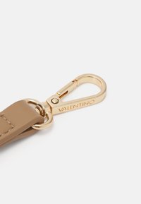 Hnědý kožený pásek s pozlaceným kovovým sponou s vyrytým nápisem "VALENTINO", hladký povrch a zaoblený tvar.