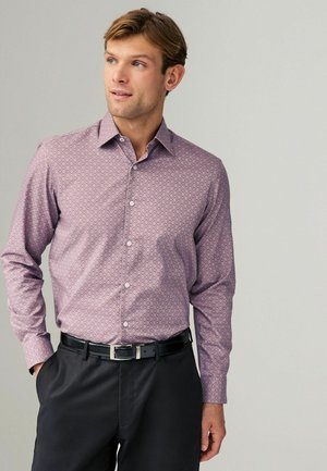 Langärmliges Hemd in Helllila mit geometrischem Muster. Verfügt über einen Button-Down-Kragen und Frontknöpfe, kombiniert mit schwarzen Hosen.